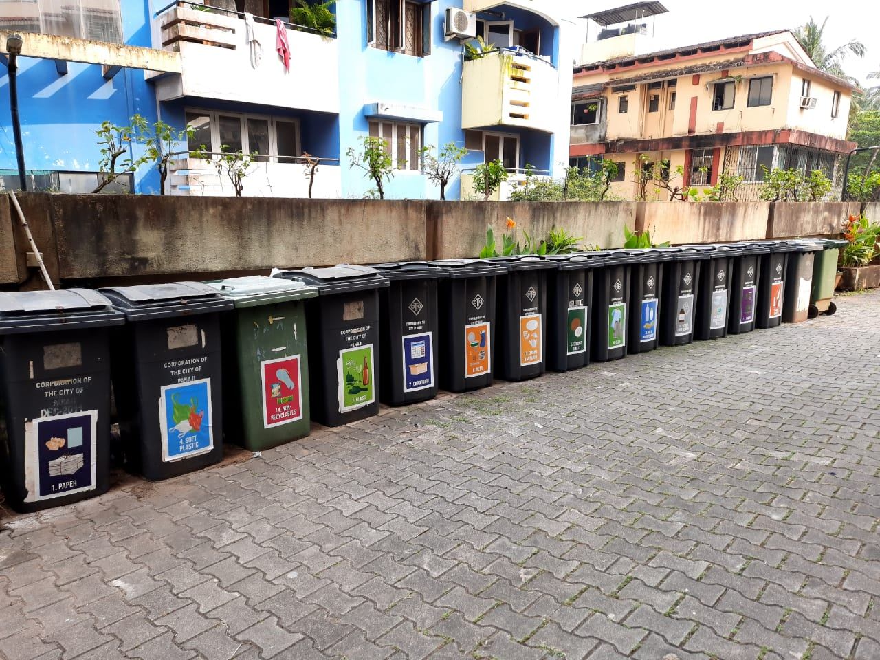 A row of colour-coded bins for 16-way waste segregation at a Panaji housing society