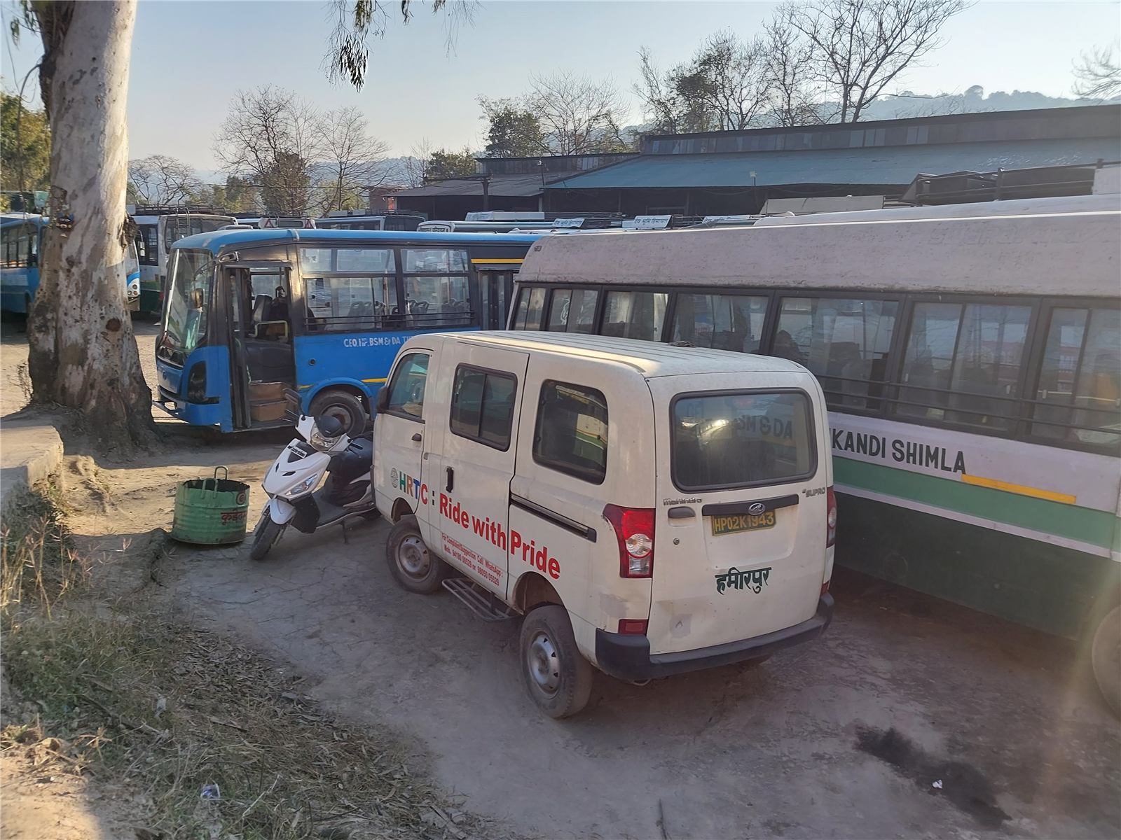 HRTC buses and a van at a bus depot in Himachal